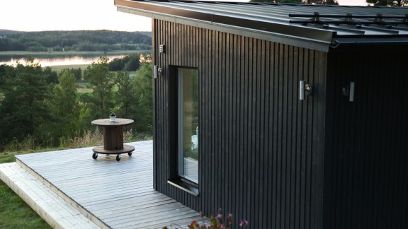 koka māja ar melnu fasādi