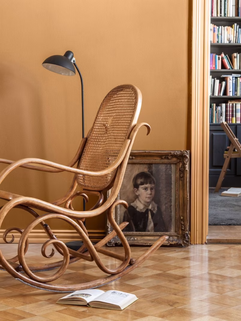 earthy yellow wall colour in living space with rocking chair 
