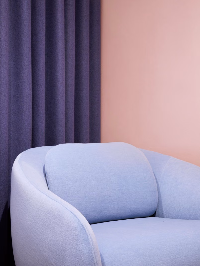 soft peach colour background wall with pastel blue sofa on front