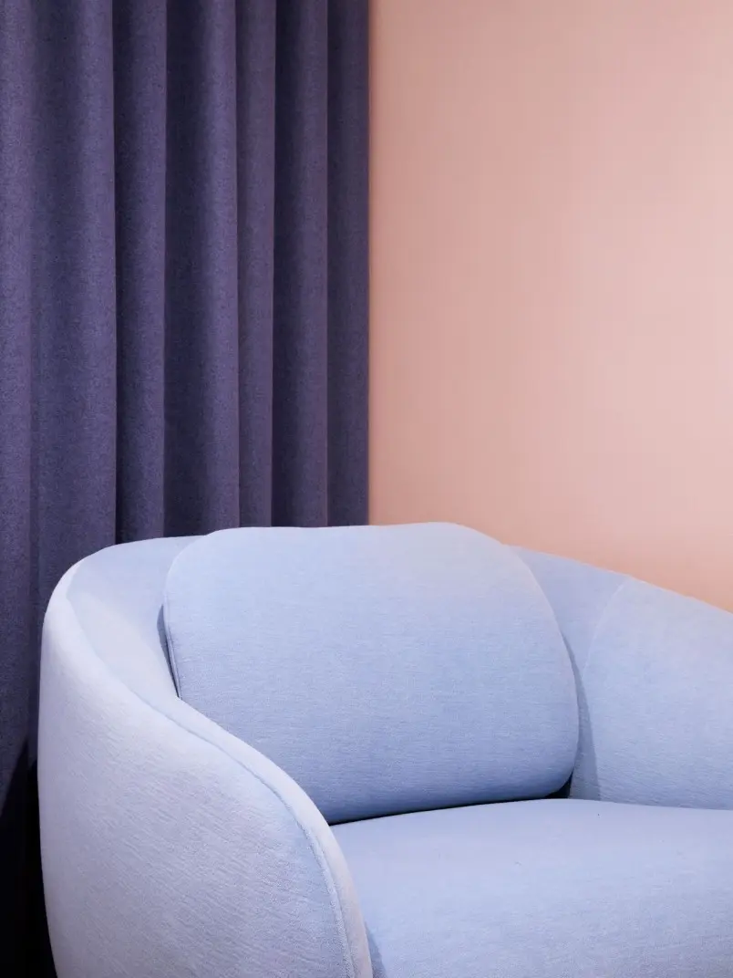 soft peach colour background wall with pastel blue sofa on front