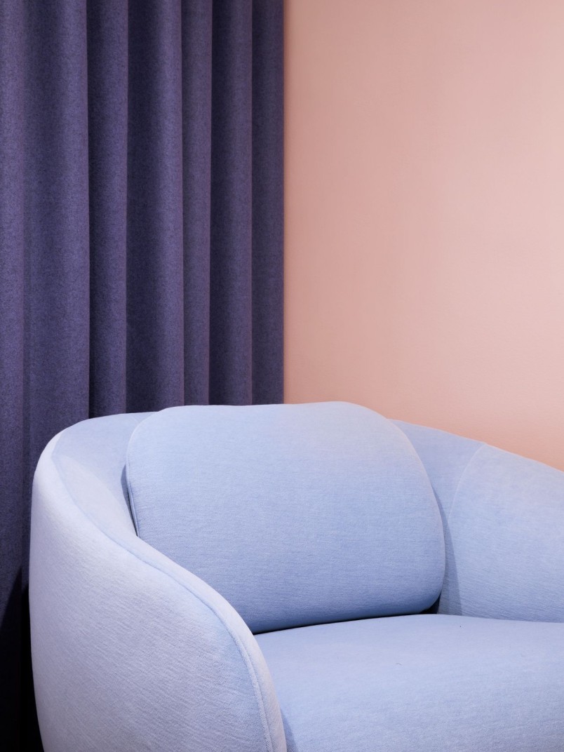 soft peach colour background wall with pastel blue sofa on front