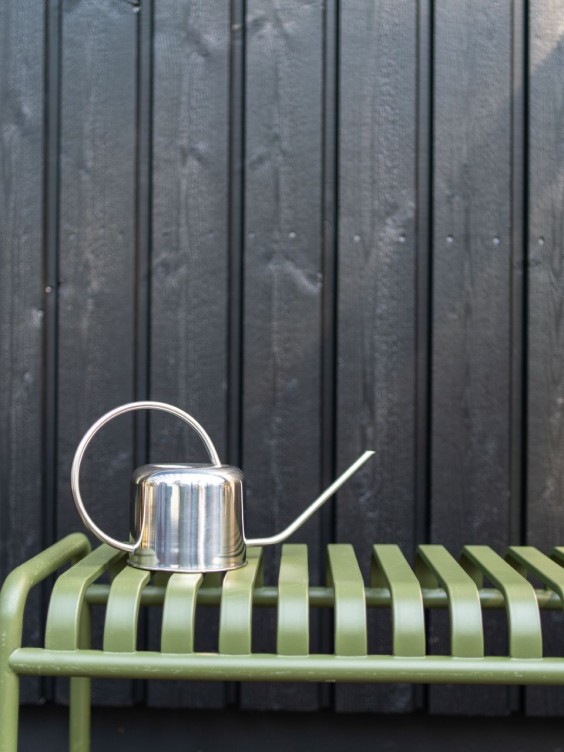 melna koka fasāde zaļš sols un lejkanna