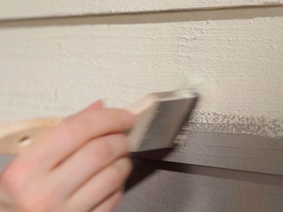 repainting wooden facade with a brush