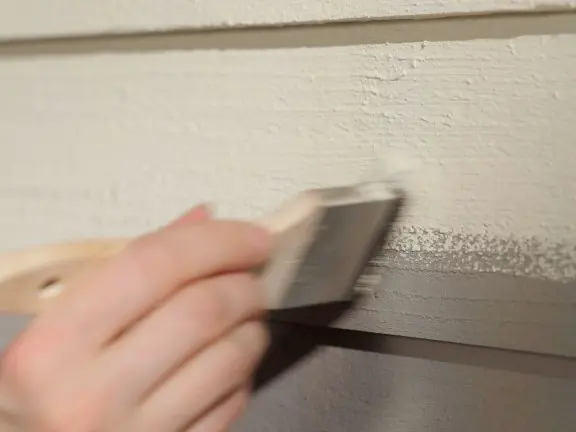 repainting wooden facade with a brush