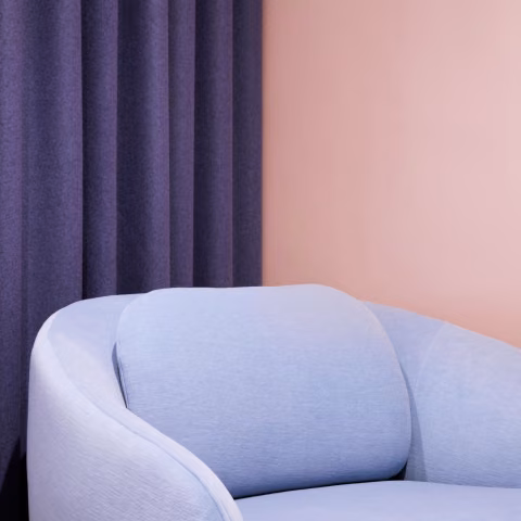 soft peach colour background wall with pastel blue sofa on front