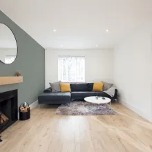 dzīvojamā istaba ar zaļu akcentu sienu