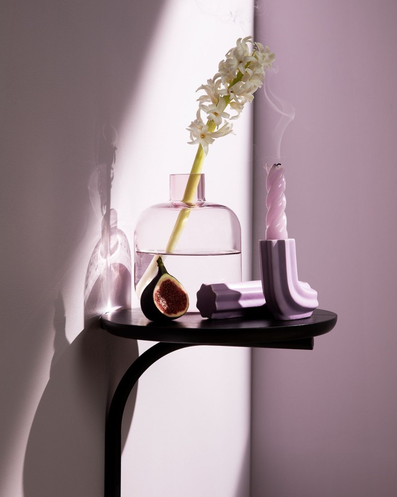 dark wooden shelf with decor items in front of soft lilac colour wall