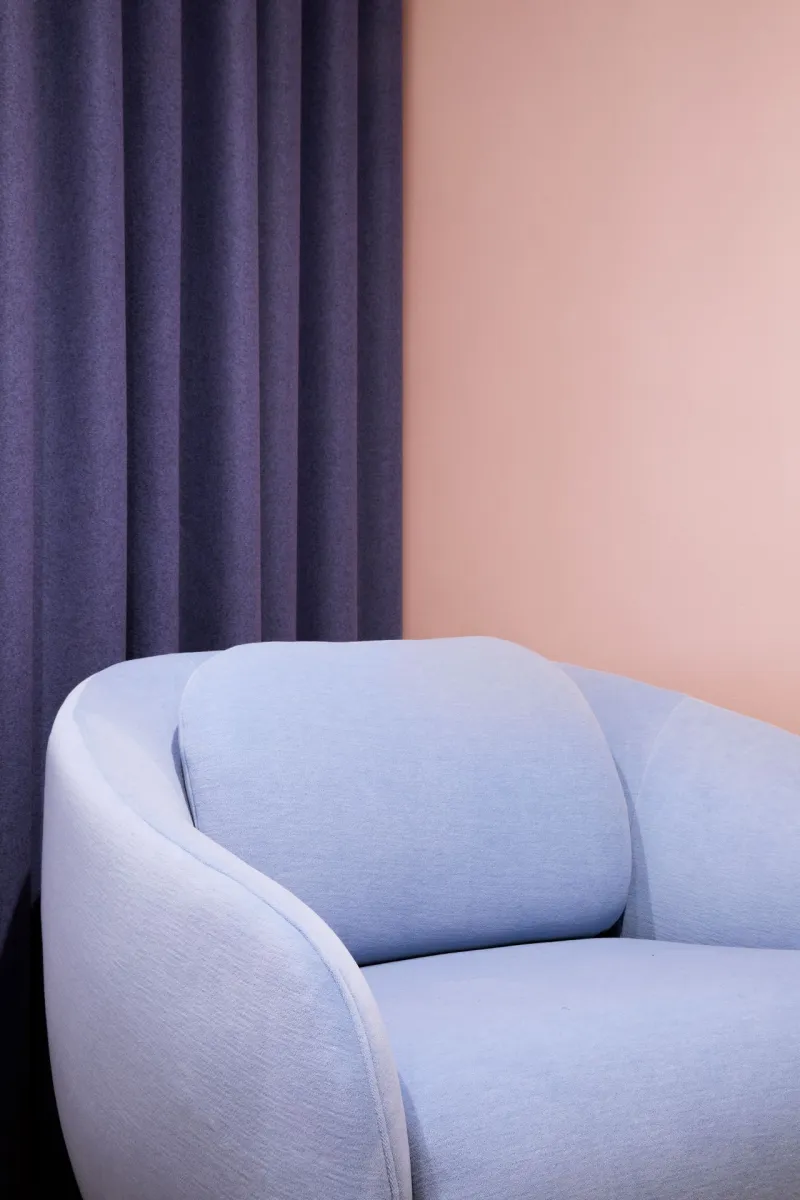 soft peach colour background wall with pastel blue sofa on front