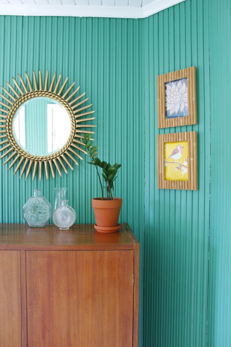 bright green wall in hallway, decorated with wooden furniture